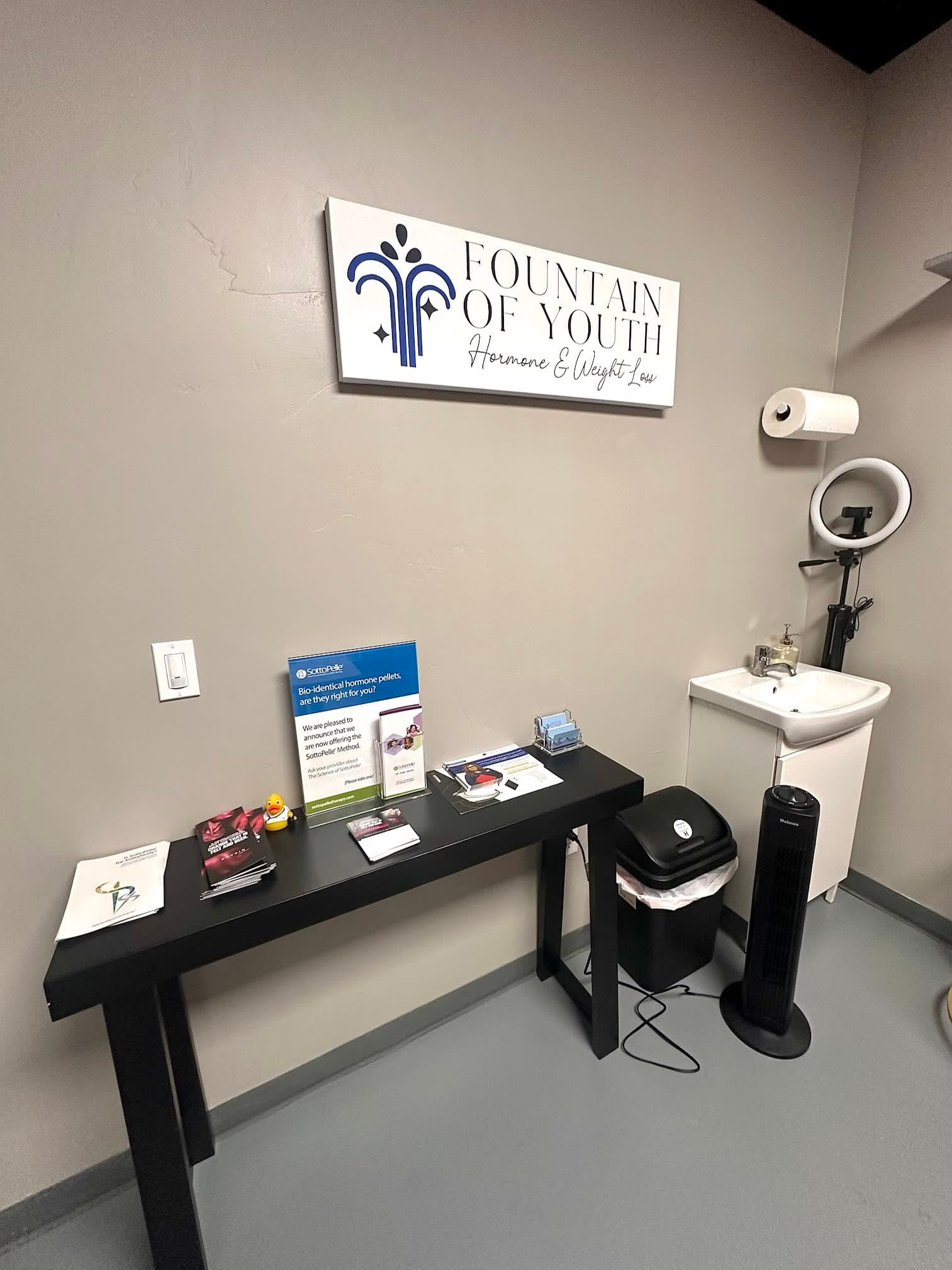 The Fountain of Youth LC intake desk in Las Cruces, with the clinic logo and patient education materials